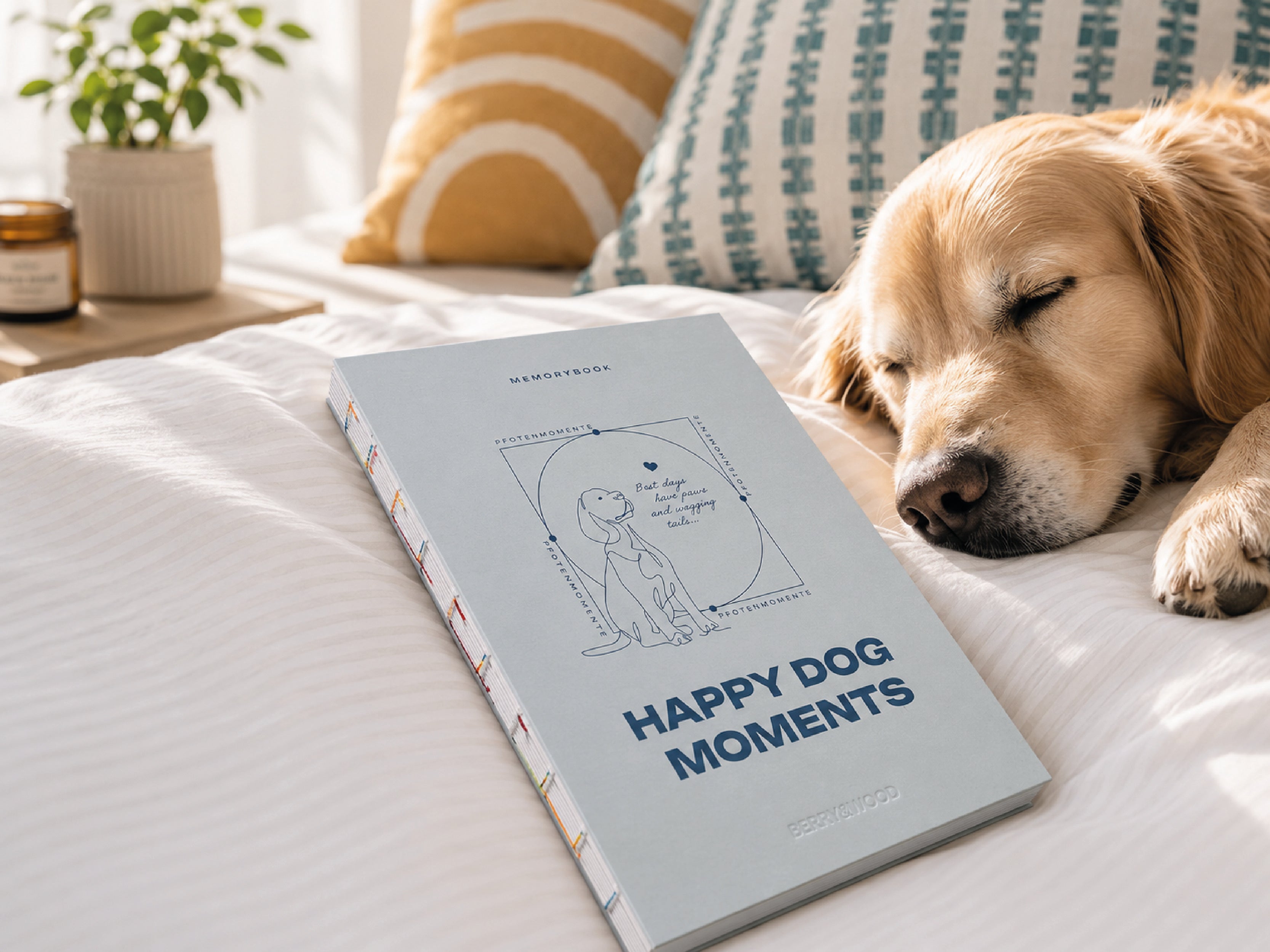 Happy Dog Moments Hundetagebuch A5 auf dem Bett, daneben ein schlafender Golden Retriever