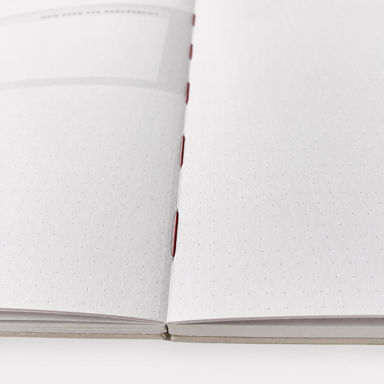 Little Big Moments Notizbuch A5 aufgeschlagen – gepunktete Seiten mit sichtbarer roter Fadenheftung
